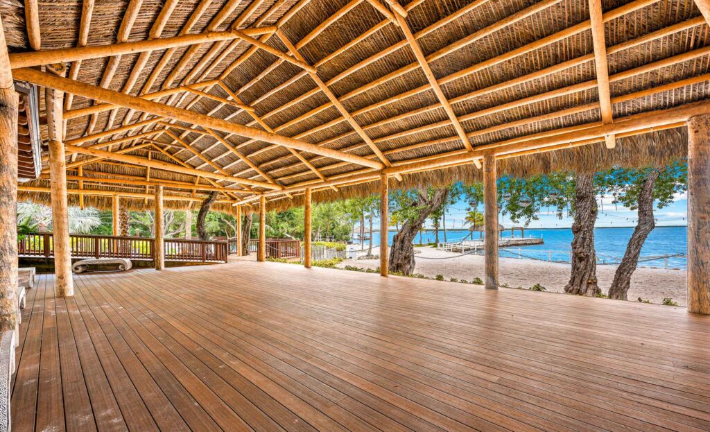 Open-air tiki pavilion at Key Largo's Largo Resort – expansive thatched hut event space with oceanfront deck, swaying palms, and azure waters for memorable beachside occasions.