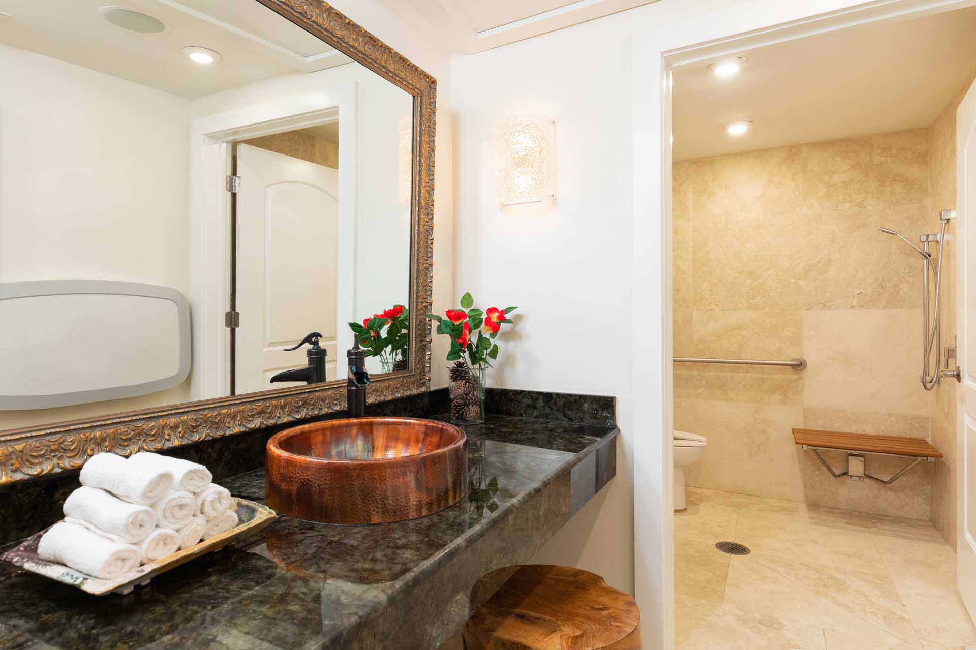 Grand Lodge bathroom with large vanity and accessible shower and water closet with bench