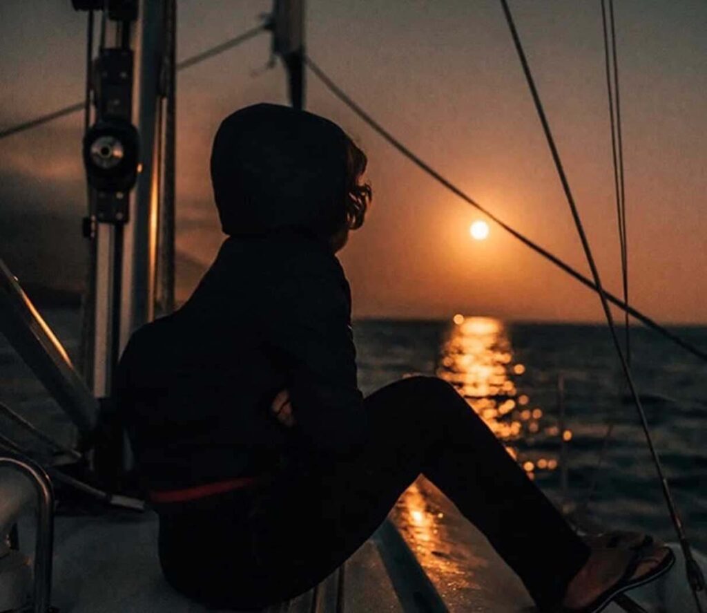 Person on a sail boat at sunset