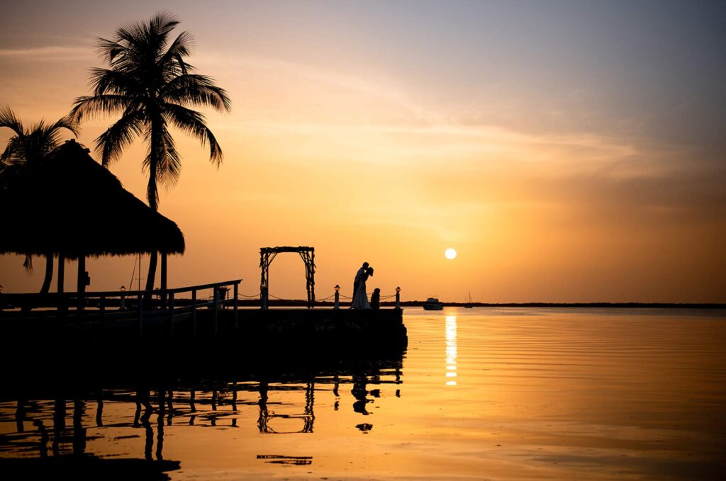 Bride and groom sharing a romantic sunset moment on the private pier at Largo Resort in Key Largo, Florida Keys – stunning waterfront wedding venue with tropical ocean views and golden hour glow
